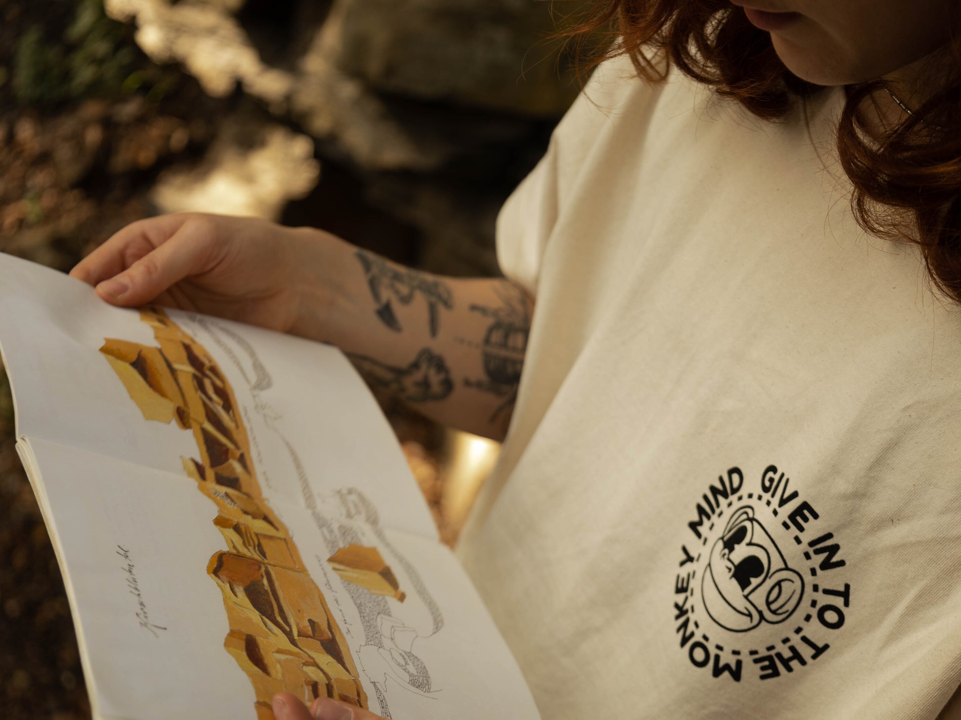 Front of monkey business Tee while reading Topo, model is wearing an S